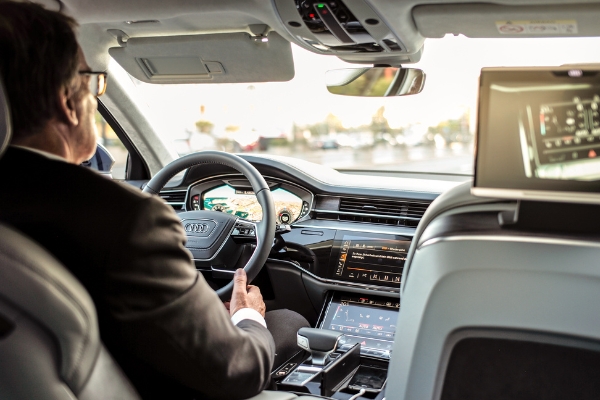 Back view of a male driver who is focused on the road ahead.