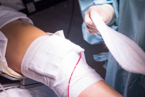 A doctor dressing the wound of a patient post-operation.