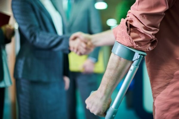 An injured person shaking hands with a their medical malpractice attorney