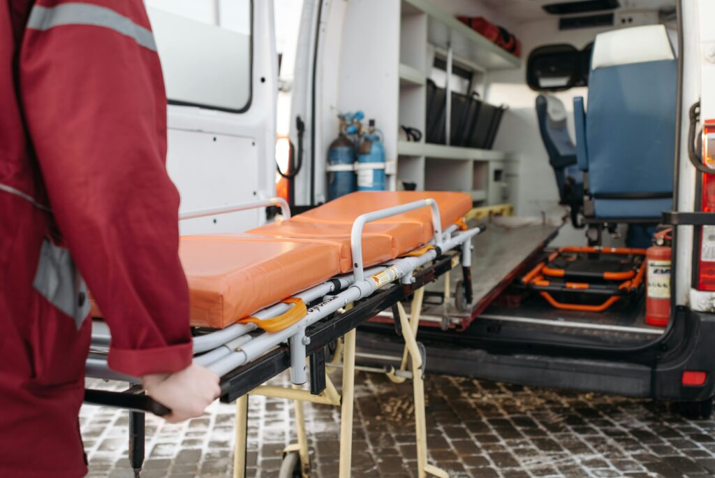 an EMT loading a stretcher into the back of an ambulance