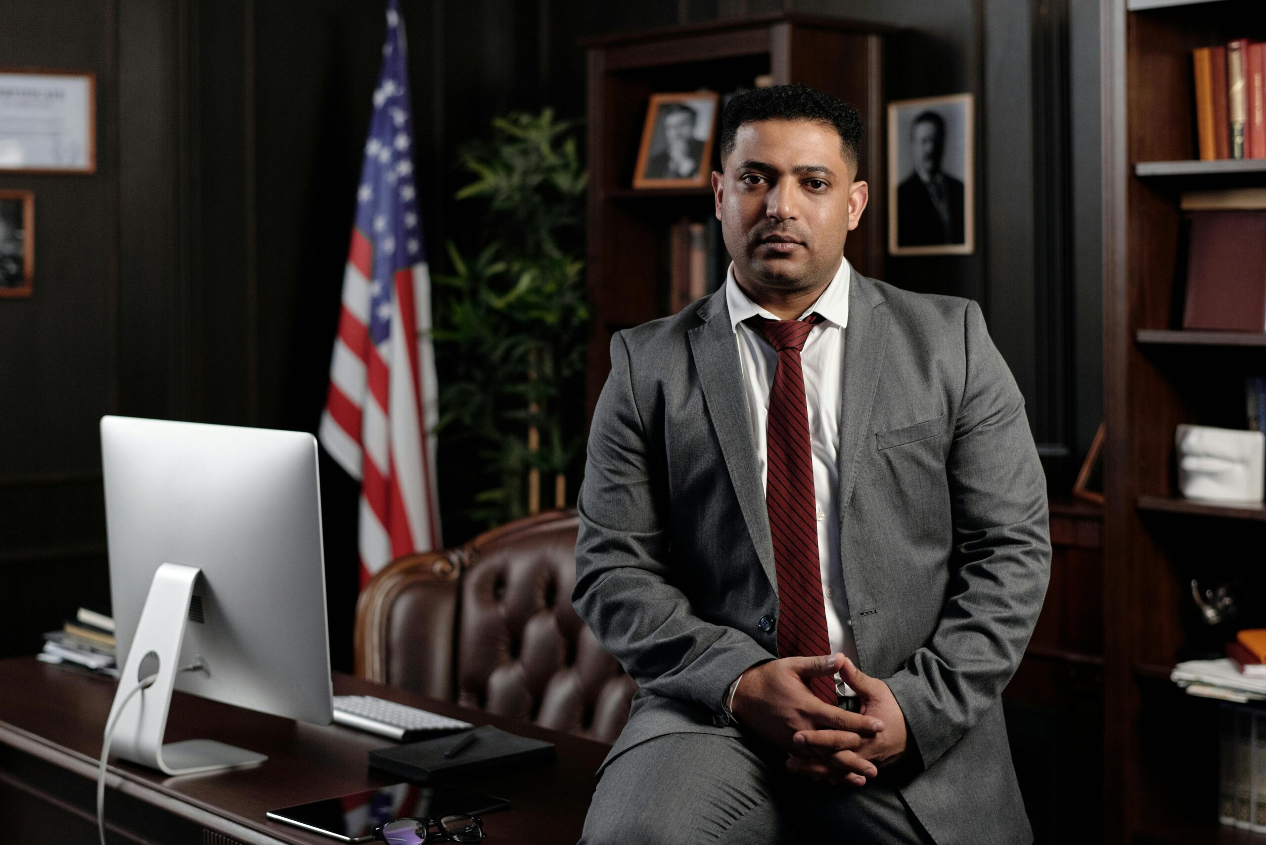 an of counsel lawyer posing in front of their desk at a law firm