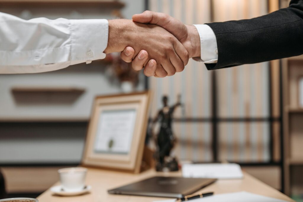 a closeup of a personal injury attorney shaking hands with their client 