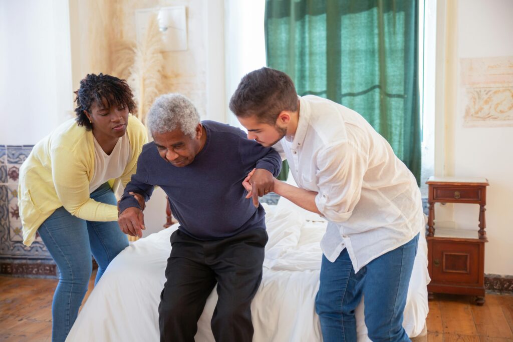 Nursing home staff helping a resident stand up